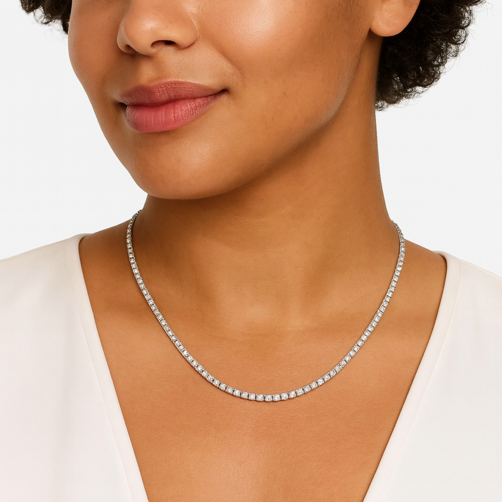 Close-up of a woman wearing a diamond tennis necklace on a white background