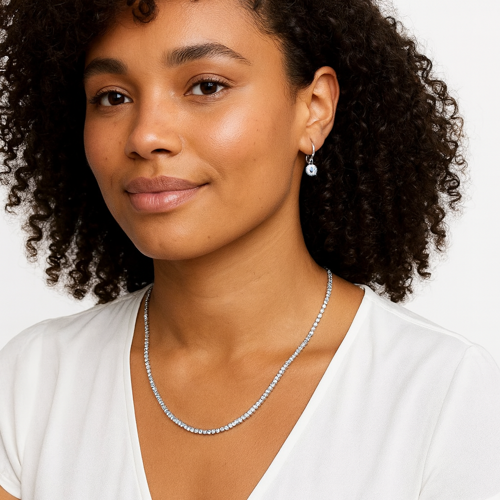 Woman wearing a diamond tennis necklace and earrings on a white background